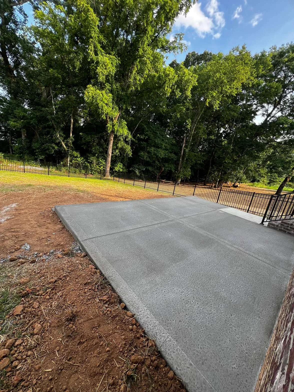 Concrete patio pad with broom finish and ornamental fence — Clarksville TN