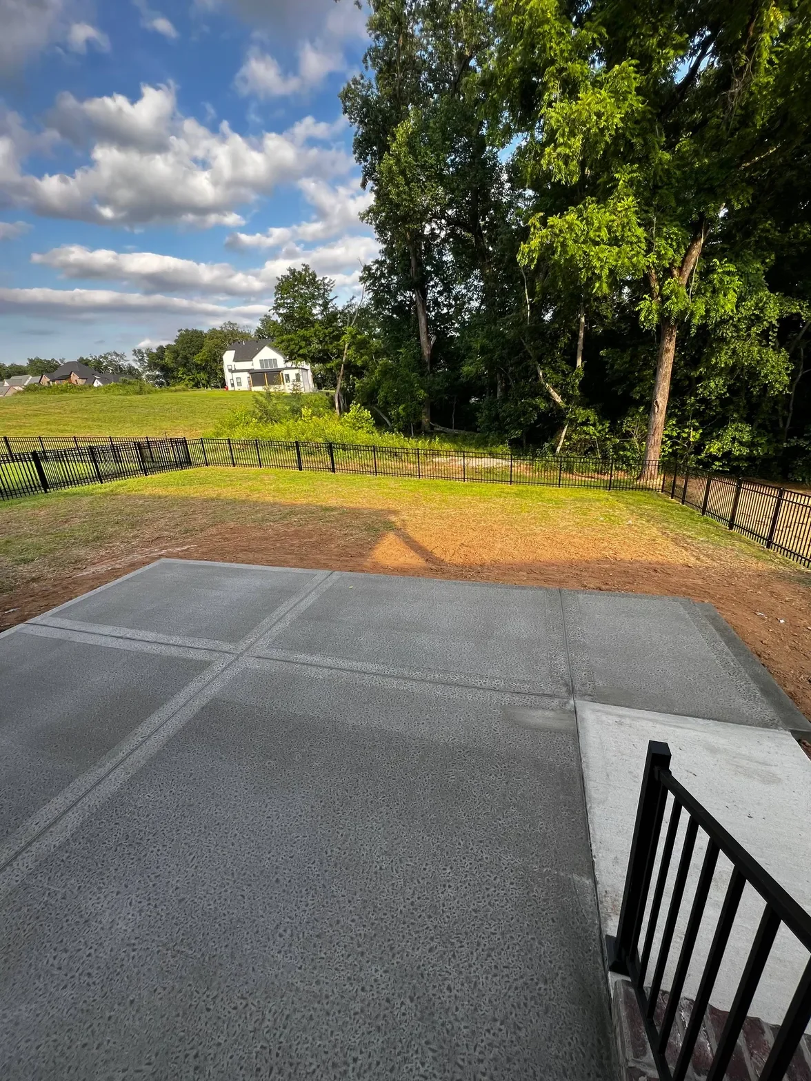 Concrete patio pad with broom finish and ornamental fence — Clarksville TN